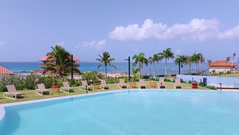 vuelo aéreo de regreso sobre la piscina y las tumbonas del hilton garden inn hotel en la romana en la república dominicana