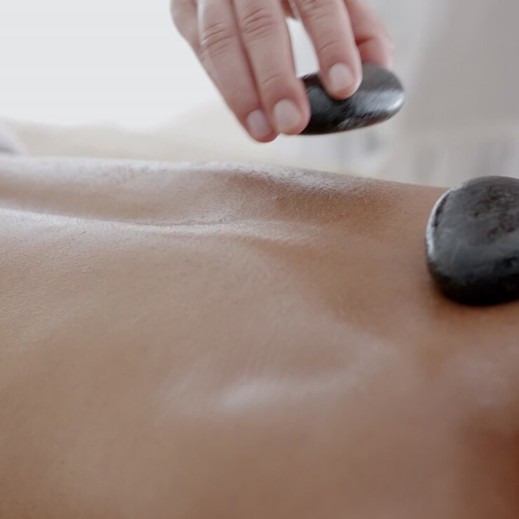 Kvinde får massage med varme sten