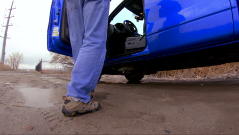 man getting in a truck or large vehicle and steps in a puddle - slow motion