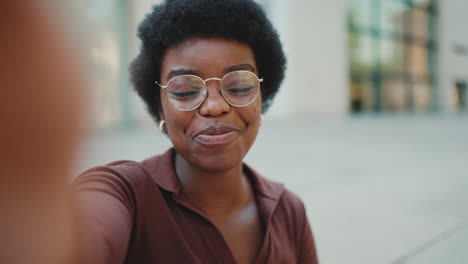 african blogger girl keeping thumb up and sending air kiss at camera