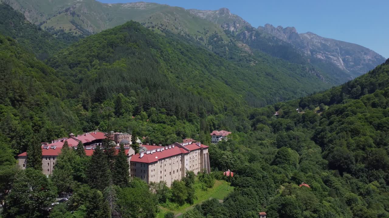 Aerial drone view of Rila Monastery amongst endless forest and Rila Mountains - Bulgaria rilski manastir Bŭlgariya