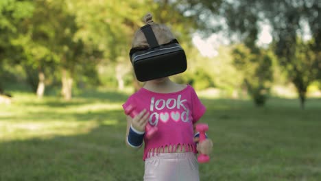 niña atlética con casco de auriculares vr haciendo ejercicios de fitness con pesas en el parque