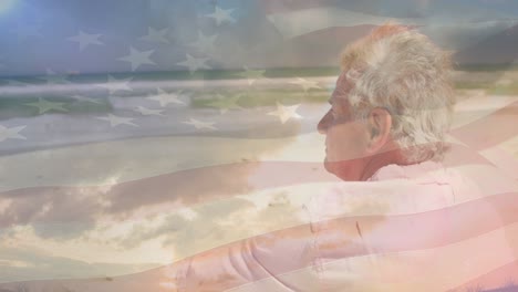 animación de un hombre caucásico sénior sentado en la playa sobre la bandera de los estados unidos de américa