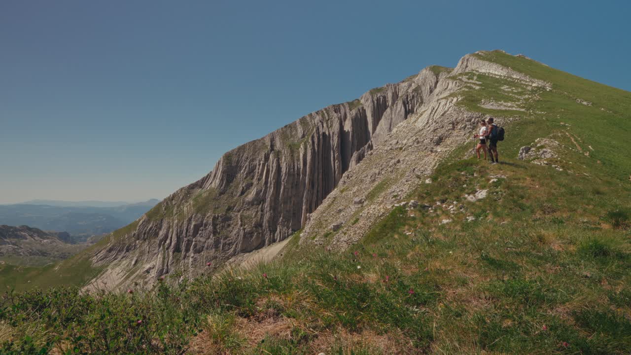 Hikers explore rugged mountain path in Durmitor's stunning landscapes