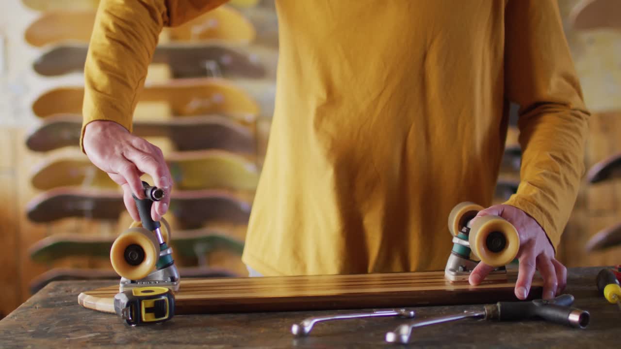 스케이트 가게 에서 스케이트 보드를 고정 하는 백인 남성 스케이트 보더 의 중간 부분 의 비디오