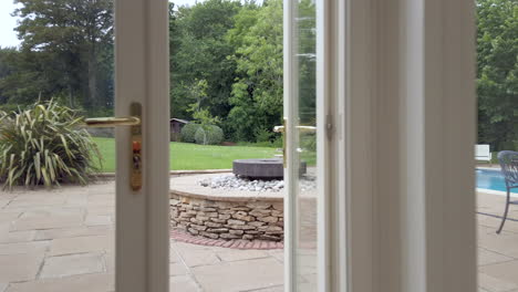 dolly shot exiting a home to reveal a large open garden