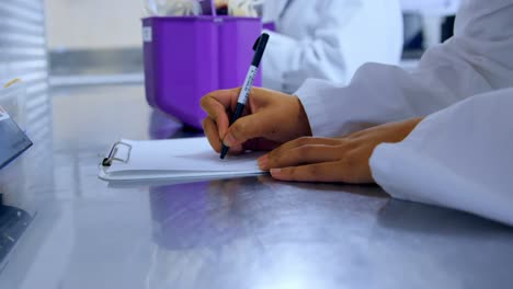 laboratory technician noting weight of blood bags 4k