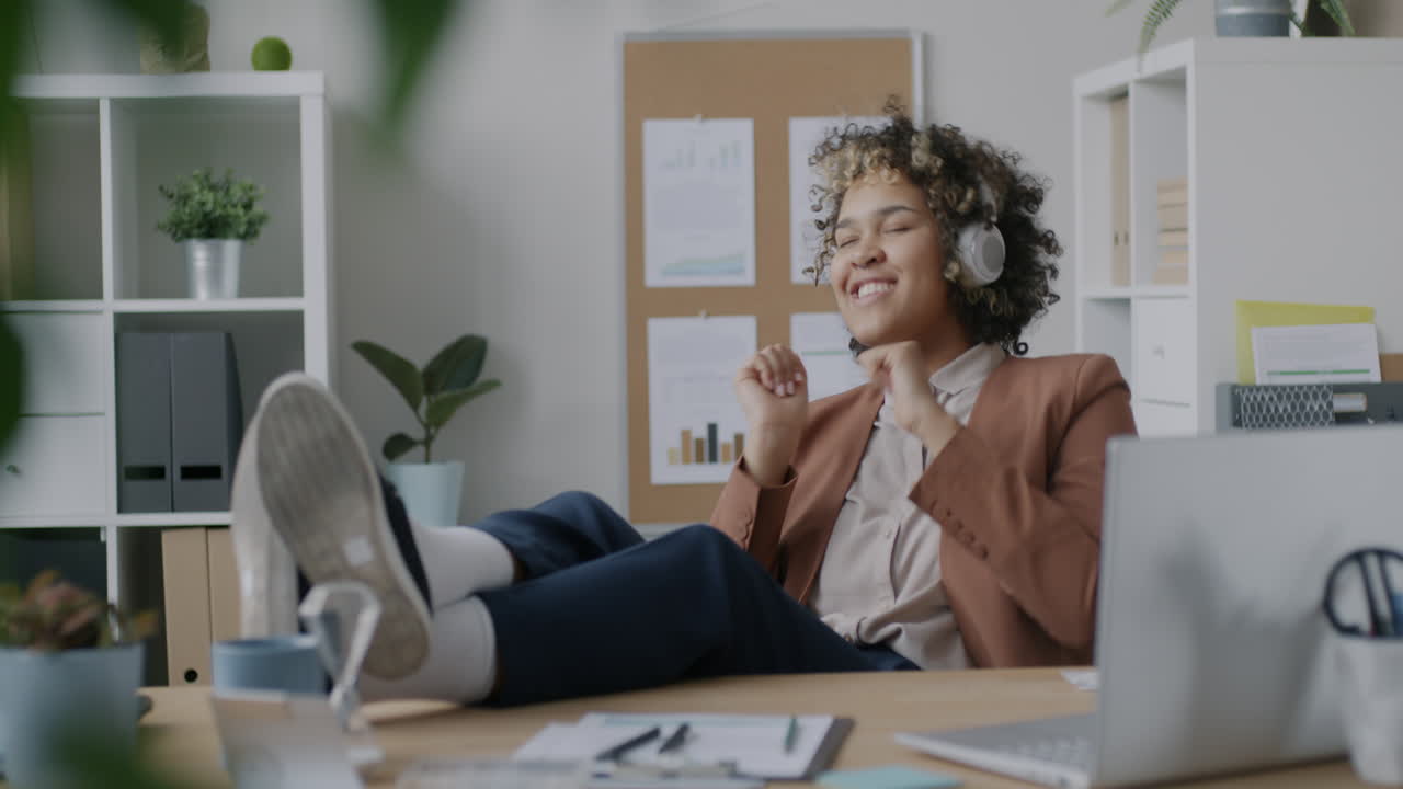 Happy Woman Relaxing in Office with Headphones