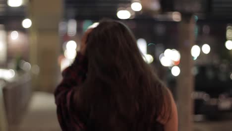 close-up tracking shot of a young woman walking around the streets moving her jacket up and down