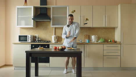 man dancing in kitchen with cooking utensils