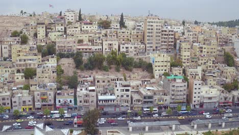 Baja-Antena-Sobre-El-Casco-Antiguo-De-La-Ciudad-De-Ammán,-Jordania-Con-Tráfico-Y-Coches-En-La-Carretera