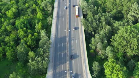 Aerial-view-of-car-traffic-on-modern-bridge-over-river-in-city-in-summer-day