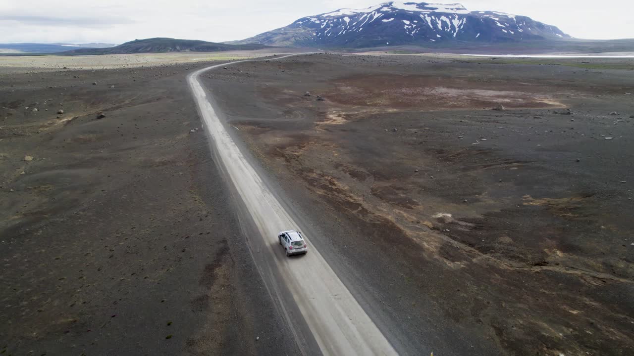 Auto che guida su terreno accidentato nella natura selvaggia dell'Islanda.