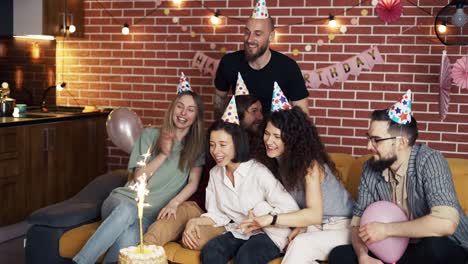 birthday girl enjoying celebration with best friends, blowing cake sparkle candle