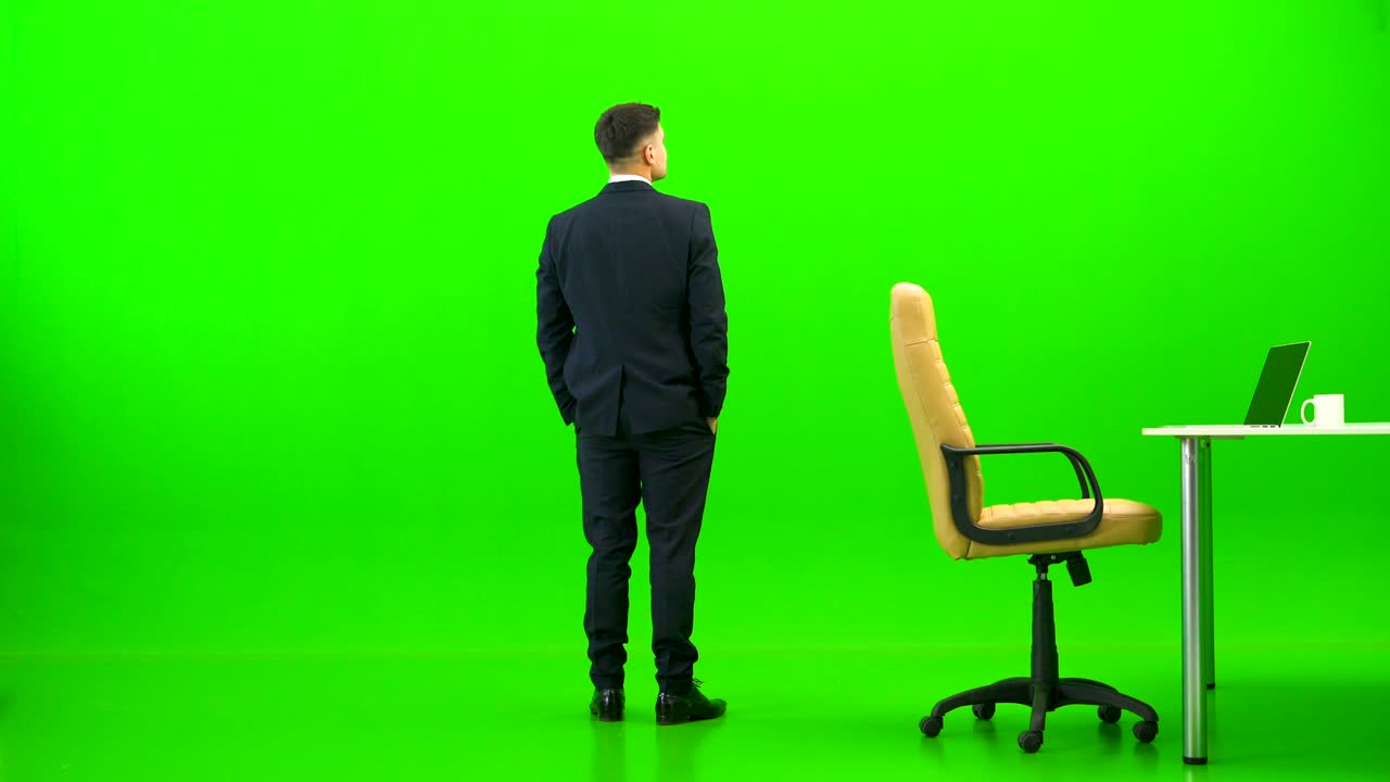 비즈니스맨이 초록색 배경의 테이블에서 휴식을 취하고 있습니다.