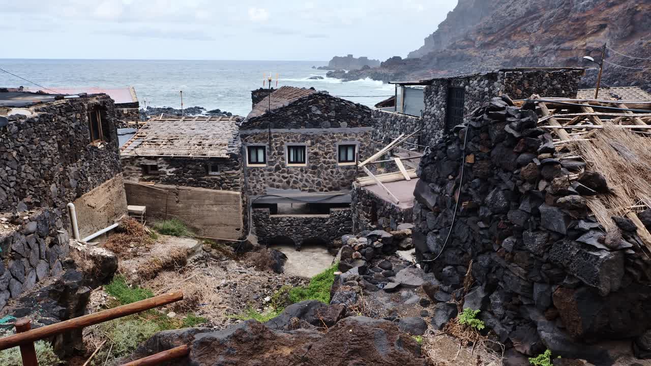 Handheld camera pans past stone house, Atlantic Ocean, El Hierro, Canary Islands