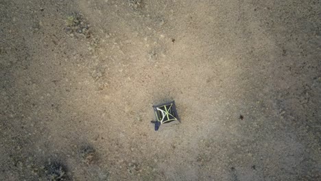 Top-down-rising-aerial-shot-of-a-lone-tent-in-the-middle-of-the-Texas-desert