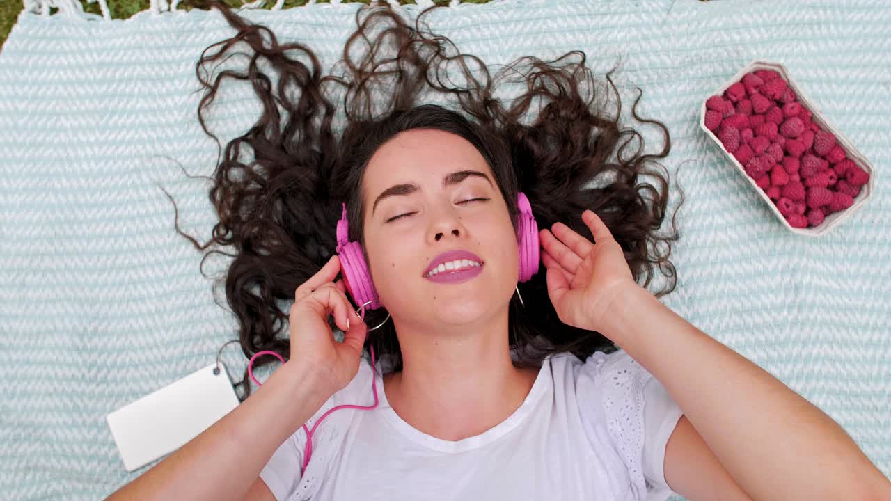 chica escuchando música con auriculares en el parque