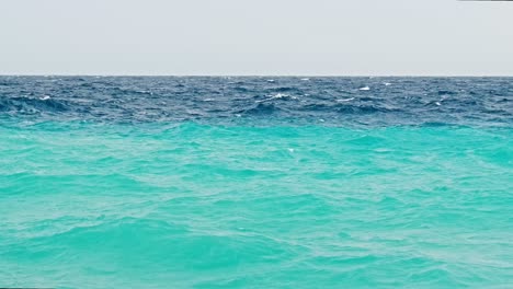 rough stormy waves during small storm over caribbean island with blue turquoise ocean and deep blue dark