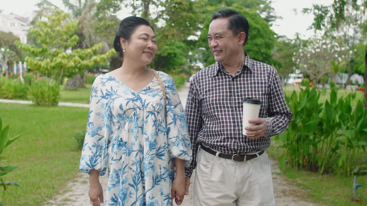 Elderly Loving Couple Chatting during Walk in Park