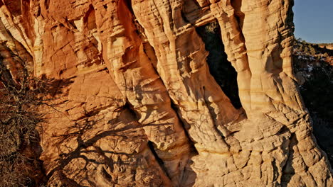 soft morning light bathes a stunning rock arch in utah’s desert, captured by drone.