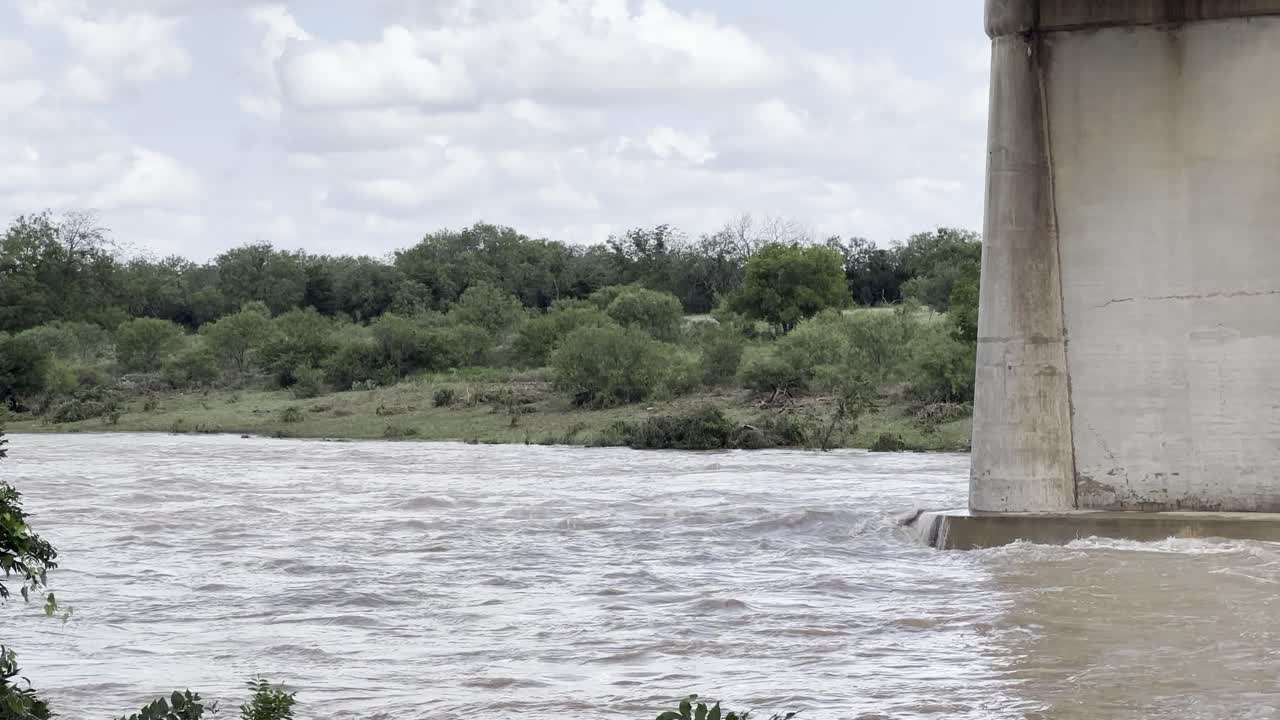 Flooded river quickly flowing below a bridge