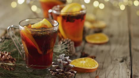 video of cups of hot tea with cinnamon and lemon over wooden background