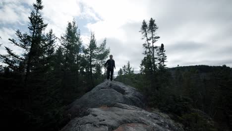 mujer caucásica excursionista corriendo por un gran sendero natural de roca en saint-come, quebec, canadá
