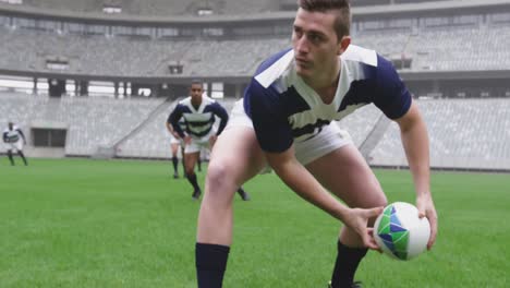 Jugador-Masculino-Pasando-Pelota-De-Rugby-En-El-Suelo-En-El-Estadio-4k