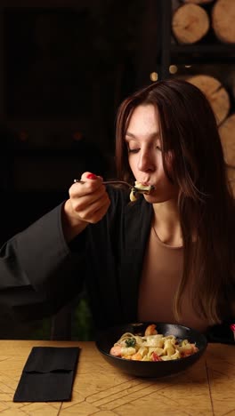 woman eating pasta in a restaurant