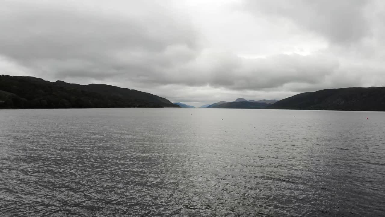 vuelo aéreo sobre las aguas del lago ness con nubes por encima