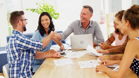 Business-colleagues-shaking-hands-in-the-office