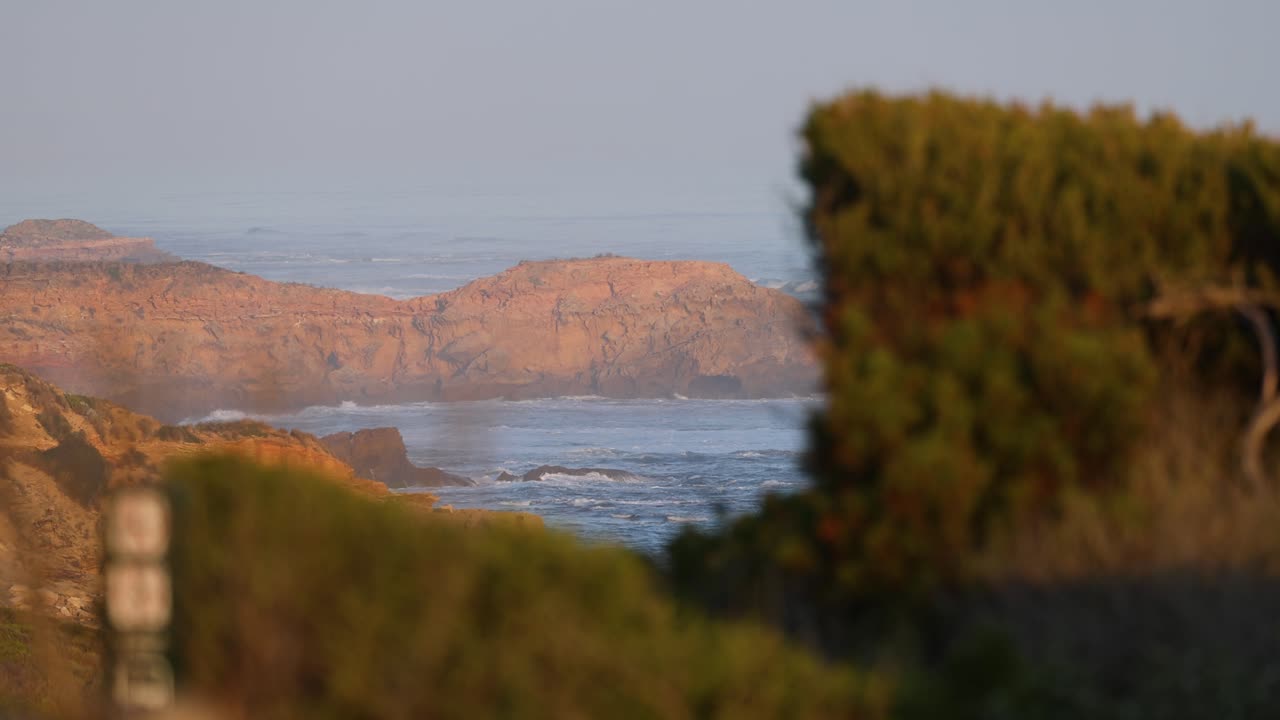해안 절벽과 바다의 파도 위에서 해가 지는 것