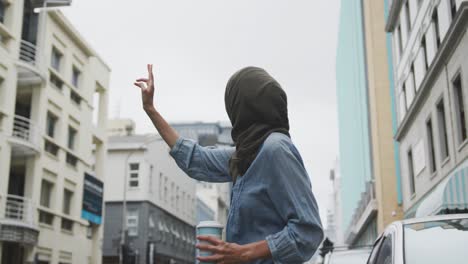 woman wearing hijab looking for a taxi