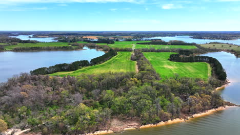 aerial view of grassy land and dense trees along the river with tranquil waters