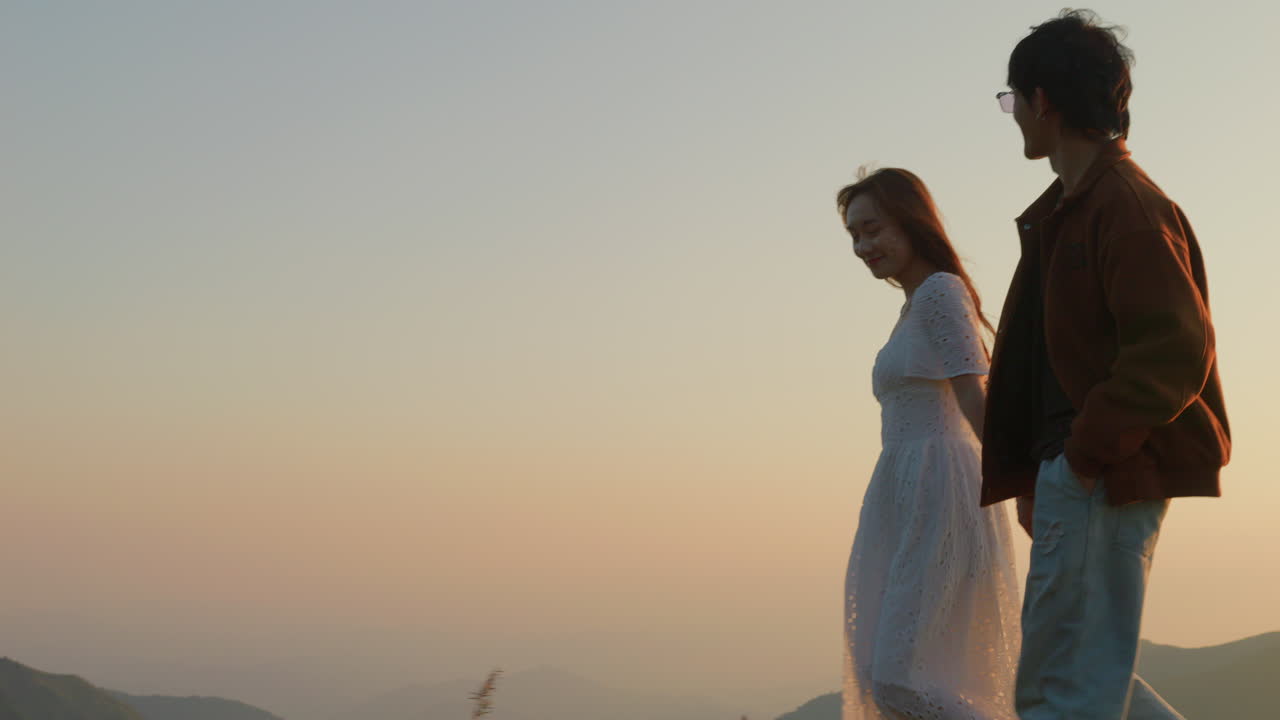 couple of young romantic lovers walk hand by hand at sunset in nature