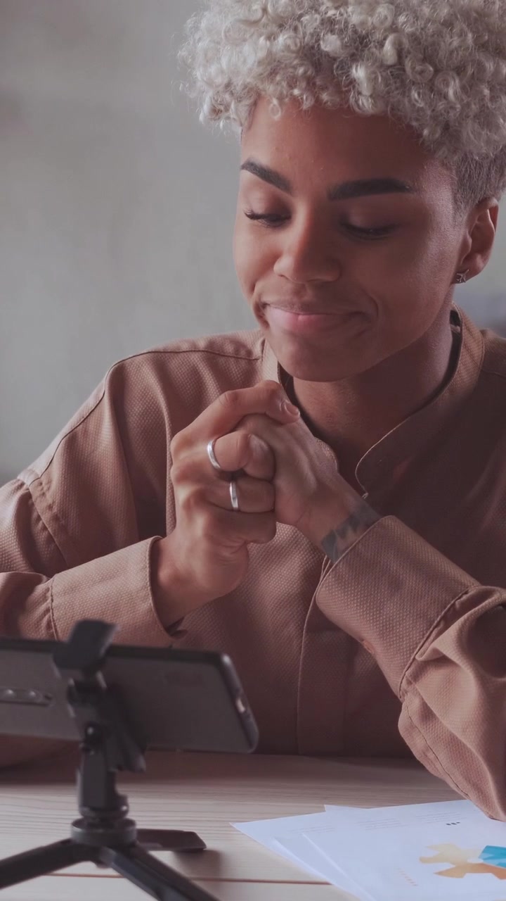 Stressed african american blogger recording video on her mobile tripod
