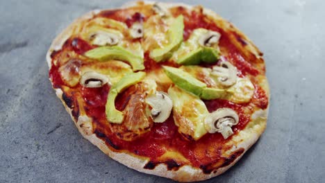 baked pizza with avocado and mushroom toppings