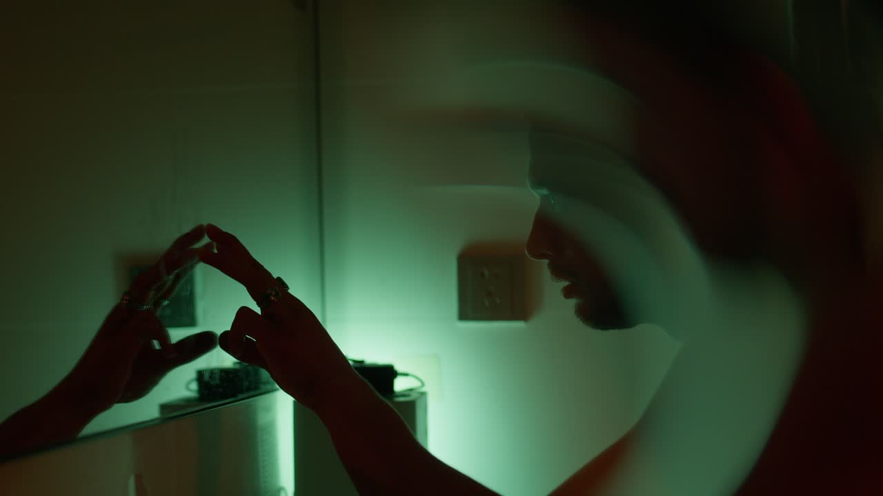 Man looking at his reflection in the mirror