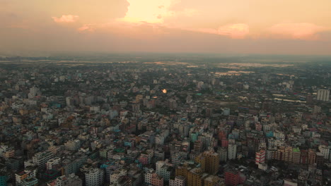 Mega-Ciudad-Con-Edificios-Densamente-Construidos,-Vista-Aérea-Con-Horizonte-Vívido---Establecimiento-De-Tiro-De-Vuelo-De-Drones