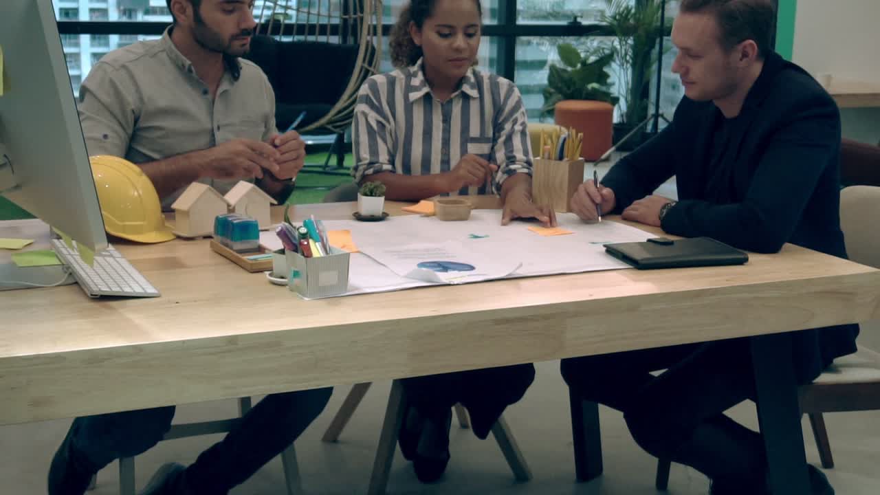 Creative business people group having conversation at office desk in workplace.