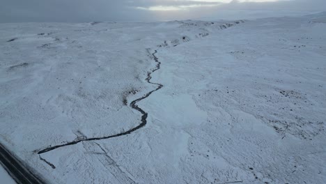 snowy sunrise of a stream in the north of iceland in the winter, aerial