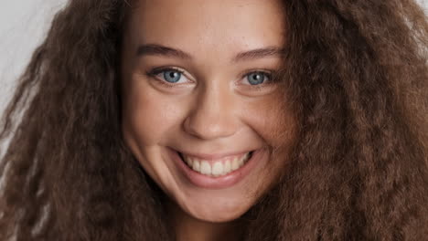 caucasian curly haired woman smiling to camara.