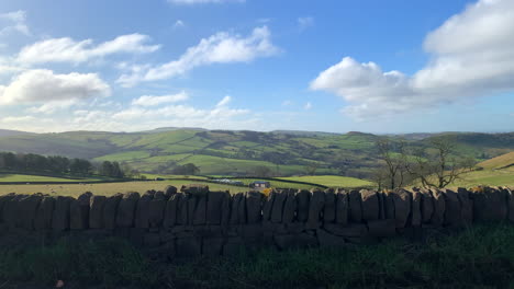 colinas onduladas en el campo británico del distrito pico en inglaterra con un muro de piedra