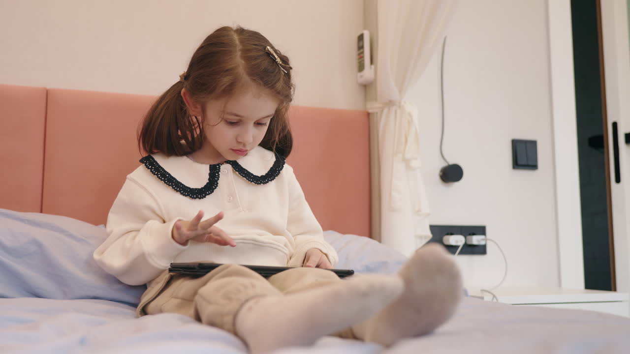 chica usando la tableta en la cama