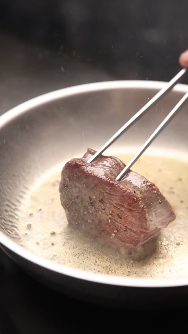 Rosolare e girare una bistecca in una padella calda con le pinze