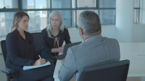 serious female hr managers interviewing mature male professional