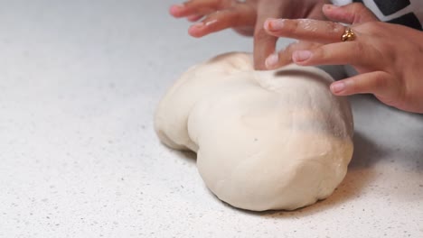 amasar masa blanca con las manos en la mesa blanca a cámara lenta