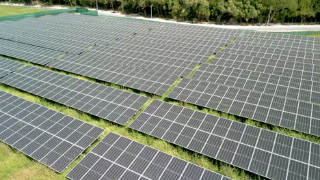 Imagen-Aérea-De-Una-Granja-De-Paneles-Solares,-Energía-Fotovoltaica,-Gran-Instalación-A-Cámara-Lenta-Con-Una-Gaviota-Volando