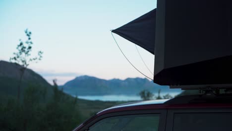 close up of suv with rooftop tent parked near the scenic fjord in flakstadvag, norway